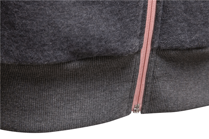 Close-up of dark gray two-tone zip hoodie with pink zipper, showcasing color block design and thick, warm fabric.